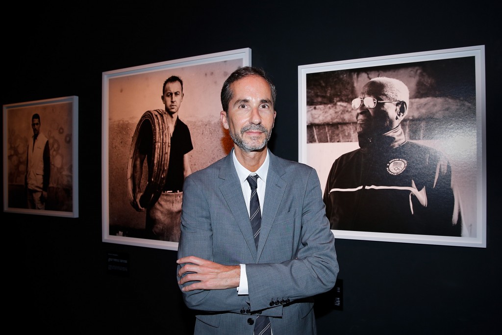 Herve Mikaeloff, Hennessy 250 Tour minister, poses in front of the Anton Corbijn portraits